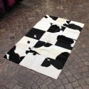 Black and white cowhide patchwork bedside rug